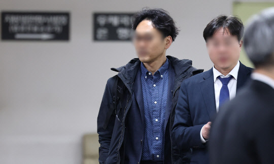 정민용 변호사가 21일 오전 서초구 서울중앙지방법원에서 열린 김용 전 민주연구원 부원장의 불법 정치자금·뇌물 수수 관련 공판에 출석하고 있다.  연합뉴스